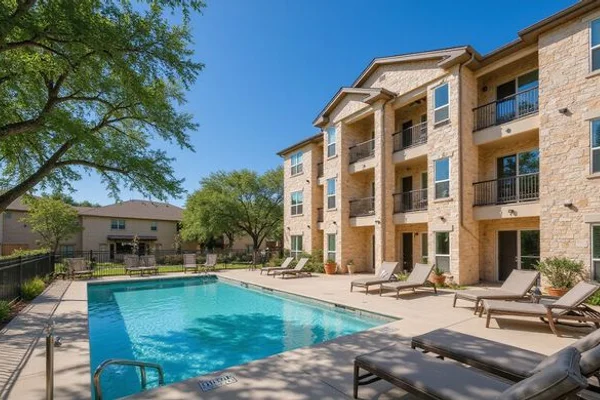 Hill Country limestone apartment building with oak trees