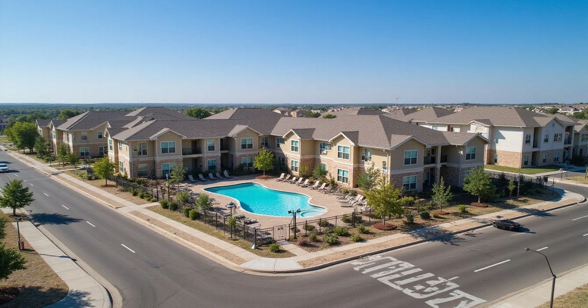 Aerial view of a new apartment community with a pool courtyard in bright sun